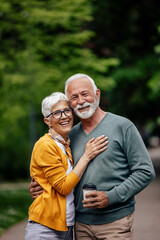 Mature woman, being hugged by her senior husband.