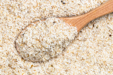 top view of wood spoon with psyllium husk close up