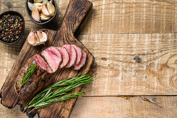 Barbecue Sliced veal tenderloin meat steak. wooden background. Top view. Copy space