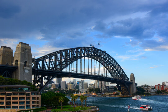 Sydney Harbour Bridge with red and white ferries traveling below it