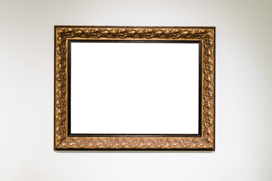 old carved wide bronze picture frame on white wall