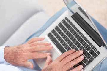 Fototapeta na wymiar Senior hands typing on laptop