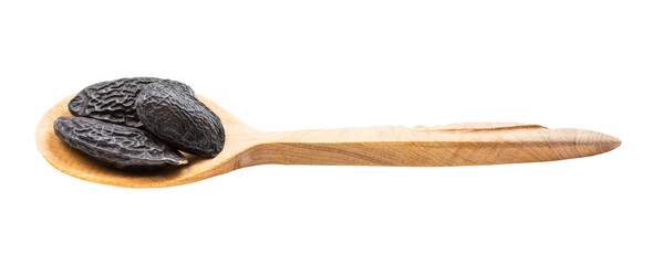 dried tonka beans in wooden spoon isolated