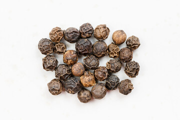 several hainan black peppercorns close up on gray