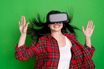 Photo of brunette impressed young lady hands up play wear 3d spectacles red shirt isolated on green color background