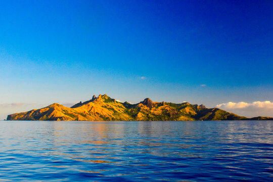 Very dramatic peaks of the northern end of Waya Island with a warm afternoon glow in Fiji's Yasawa Islands located in the South Pacific