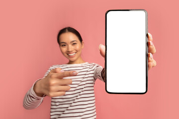 Smiling Asian Woman Pointing On Smartphone With Blank White Screen In Hands