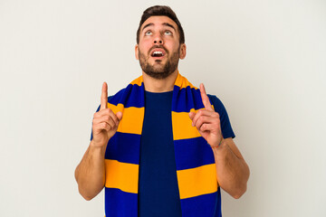 Young caucasian fan of a soccer team isolated on white background pointing upside with opened mouth.