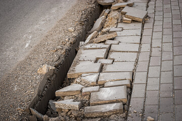 Street sidewalk damaged pavement with trench along. Street repair works
