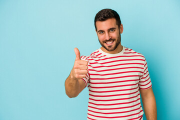 Young caucasian man isolated on blue background smiling and raising thumb up
