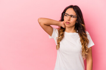 Young mexican woman isolated on pink background touching back of head, thinking and making a choice.