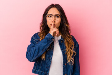 Young mexican woman isolated on pink background keeping a secret or asking for silence.