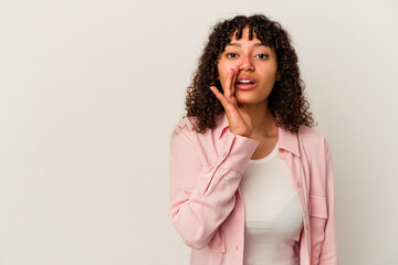 Young mixed race woman isolated on white background is saying a secret hot braking news and looking aside