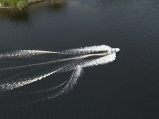 Motor boat with water skis on the river. Aerial drone view.