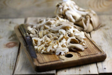 Sliced oyster mushrooms on a wooden board.