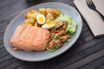 steamed salmon fillet with potato wedges, guacamole homemade and quail egg
