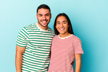 Fototapeta premium Young mixed race couple isolated on blue background happy, smiling and cheerful.