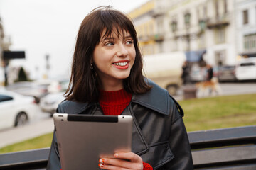 Smiling young white woman wearing leather jacket