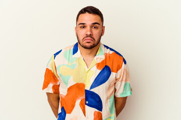 Young caucasian man isolated on white background shrugs shoulders and open eyes confused.