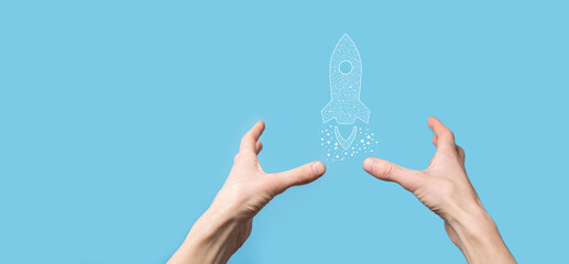 Male hand holding digital transparent rocket icon.Startup business concept. Rocket is launching and soar flying.Concept of business idea.
