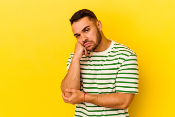 Young caucasian man isolated on yellow background who feels sad and pensive, looking at copy space.