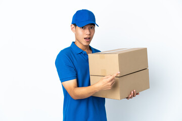Delivery Chinese man isolated on white background surprised and pointing side