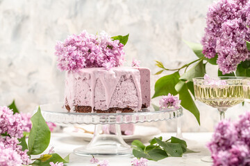 Obraz na płótnie Canvas Delicious berry mousse cake, with prosecco, champagne, wine, bouquet of purple blooming lilacs, French cuisine, postcard, background