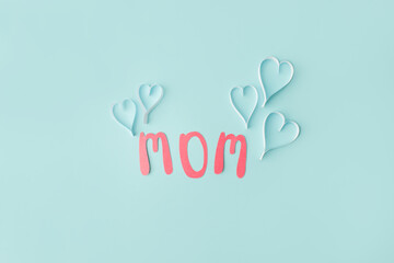 Mothers day message on paper cut hearts over blue background, simple diy creative idea, banner,...