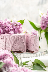 velvet mousse cake with blueberries decorated with a bouquet of purple blooming lilac, French cuisine, postcard, background, , vertical image place for text
