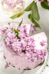 Fototapeta na wymiar velvet mousse cake with blueberries decorated with a bouquet of purple blooming lilac, French cuisine, postcard, background, , vertical image place for text