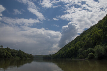 river clouds blue sky and green shores