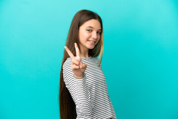 Little girl over isolated blue background smiling and showing victory sign