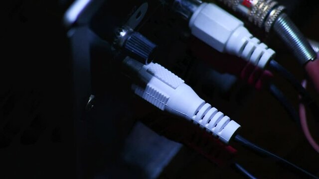 Male hand plluging RCA cables. Close-up from above.