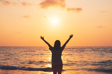 Fototapeta na wymiar Copy space of woman rise hand up on sunset sky at beach and island background.