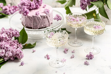 Obraz na płótnie Canvas Delicious prosecco, champagne, wine with berry mousse cake bouquet of purple blooming lilacs, French cuisine, postcard, background