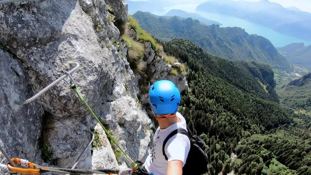 Climber Resting on the Exposed Corna delle Capre Via Ferrata Above Lake Iseo, Italy