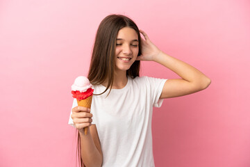 Little girl with a cornet ice cream over isolated pink background smiling a lot