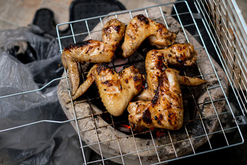 Chicken wings on barbecue grill with fire, Top view.