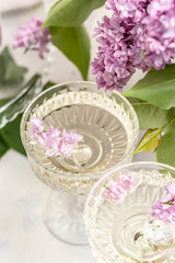 prosecco, champagne, wine with bouquet of purple blooming lilacs, postcard, background. vertical...
