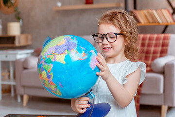 little schoolgirl girl holding a globe