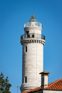 The ancient lighthouse of the island of Murano made of white stones. Punta Faro, Venice lagoon, UNESCO world heritage site, Veneto, Italy, Europe. 