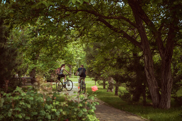 Naklejka premium people ride bicycles in the park summer day