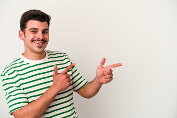 Young caucasian man isolated on white background excited pointing with forefingers away.