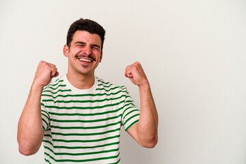 Fototapeta premium Young caucasian man isolated on white background raising fist after a victory, winner concept.
