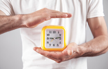 Man holding yellow clock. Business. Time management