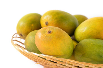 indian mangos in a basket on a white background in close up view