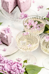 prosecco, champagne, wine and blueberry tart with bouquet of purple blooming lilacs, postcard, background. vertical image place for text