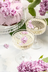 Obraz na płótnie Canvas prosecco, champagne, wine and blueberry tart with bouquet of purple blooming lilacs, postcard, background. vertical image place for text