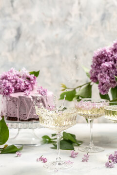 prosecco, champagne, wine and blueberry tart with bouquet of purple blooming lilacs, postcard, background. vertical image place for text