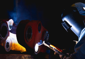 Industrial welder welding fabricated construction in factory, Welding process by Shielded Metal Arc...